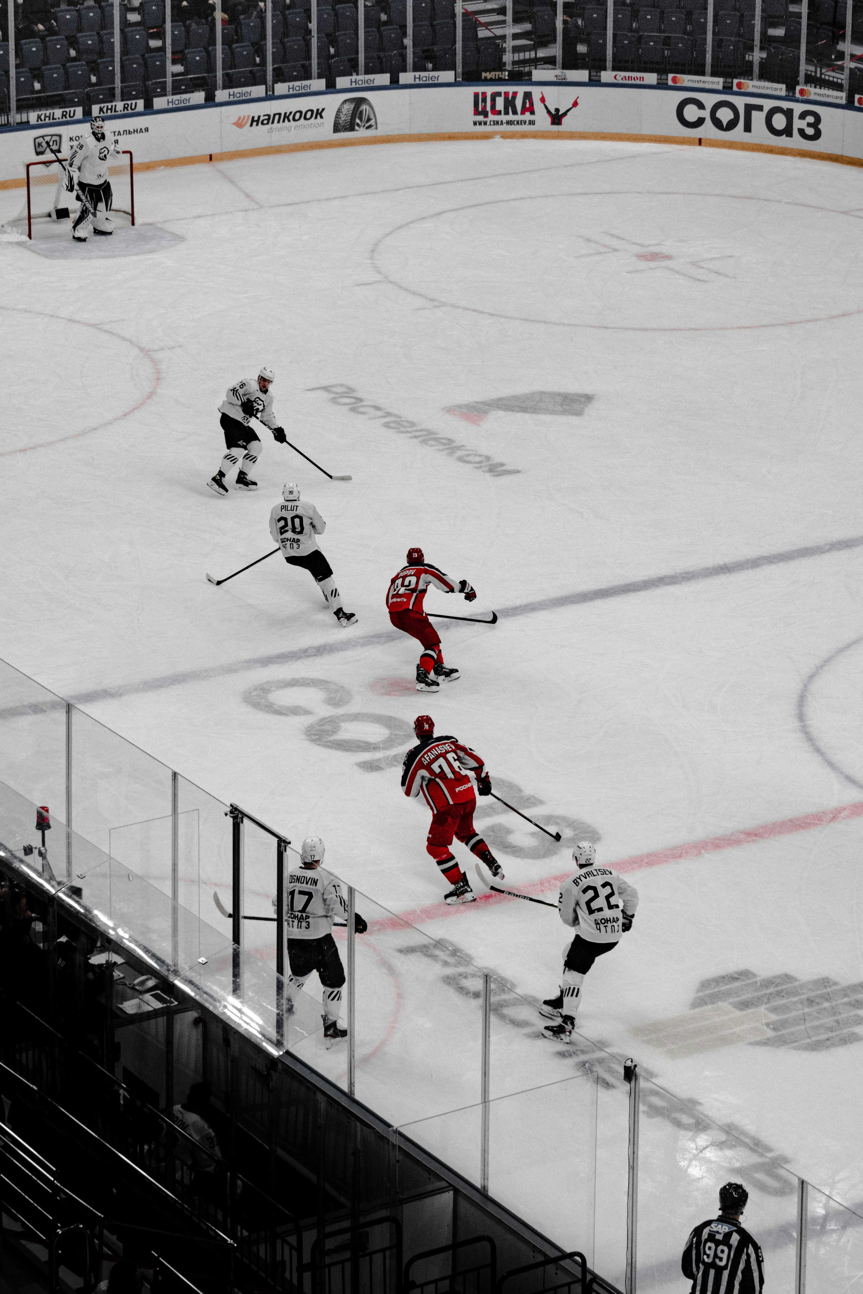 2 men in red and white ice hockey jersey playing on ice hockey field