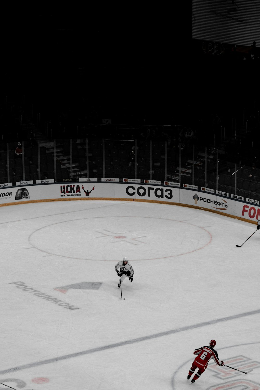 man in black jacket riding on ice hockey field