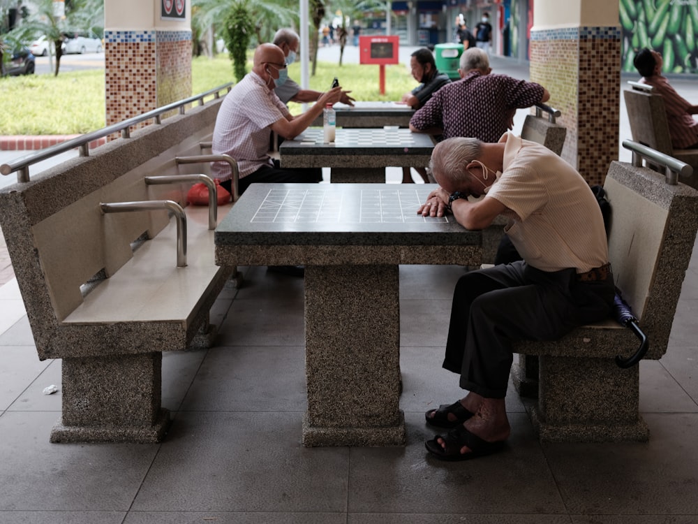 man in white t-shirt sitting on bench