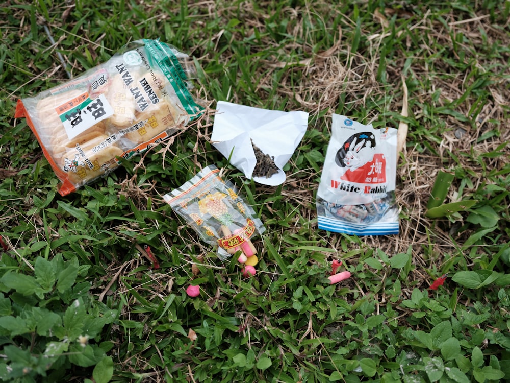 weiße und orangefarbene Plastikpackung auf grünem Gras