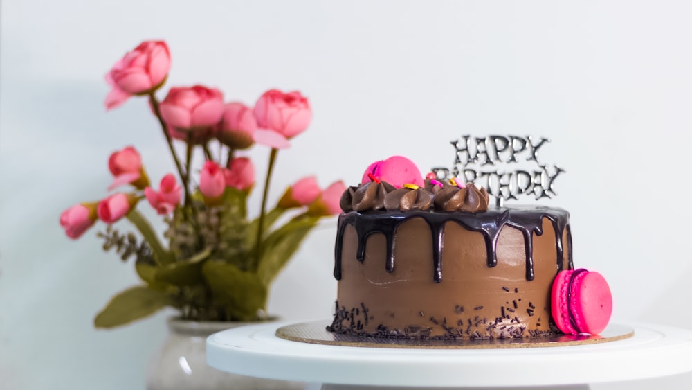 chocolate cake with pink rose on white ceramic plate