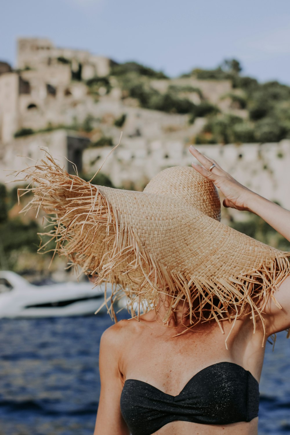 woman in brown sun hat sitting on beach during daytime