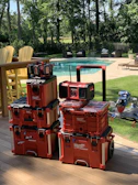 Stacked toolboxes with various power tools inside, ready for pickup.