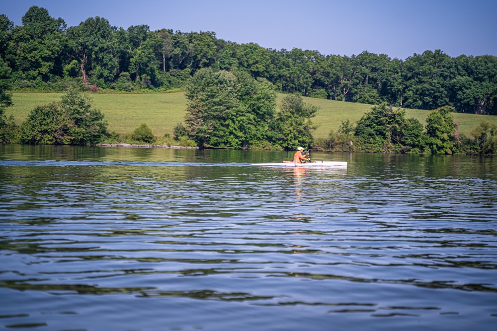 person in red kayak on lake during daytime