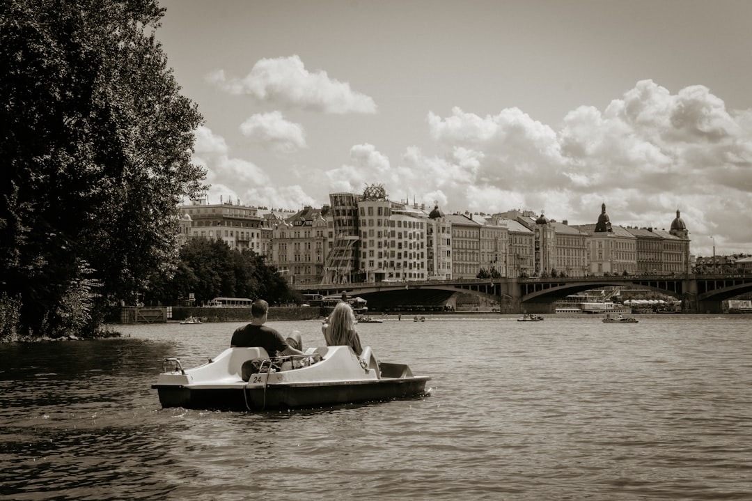 grayscale photo of couple riding on boat on river