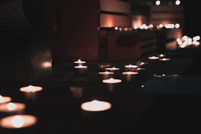 Softly lit candles arranged on a white linen cloth, highlighting their clean design and artisanal quality.
