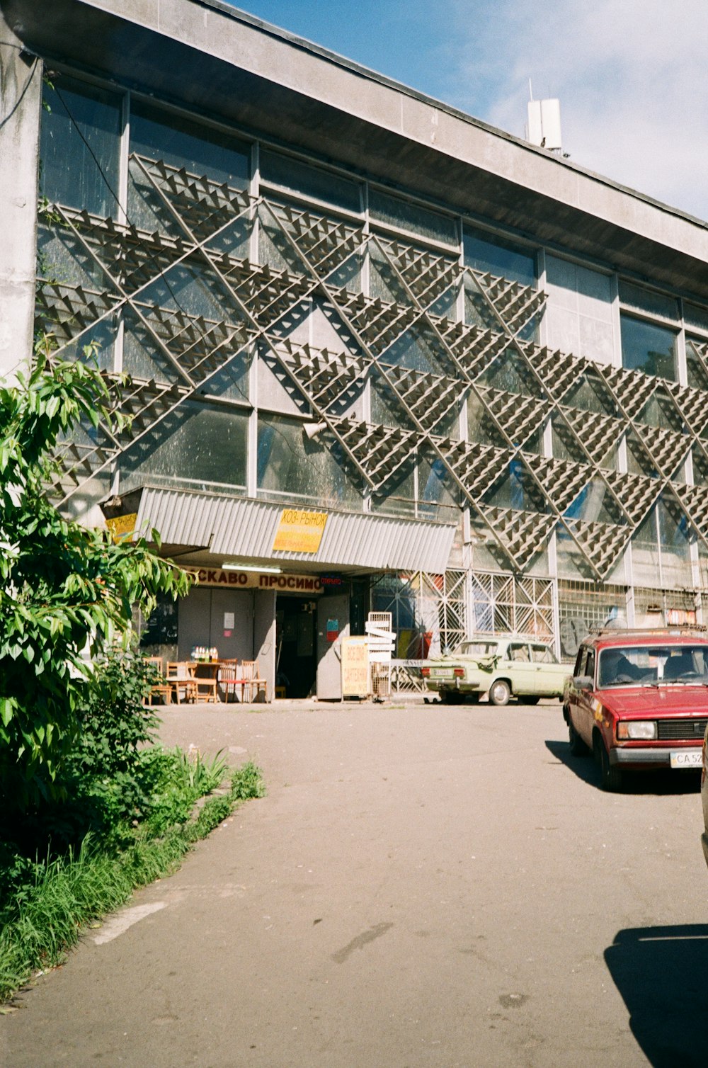 red car parked in front of white building