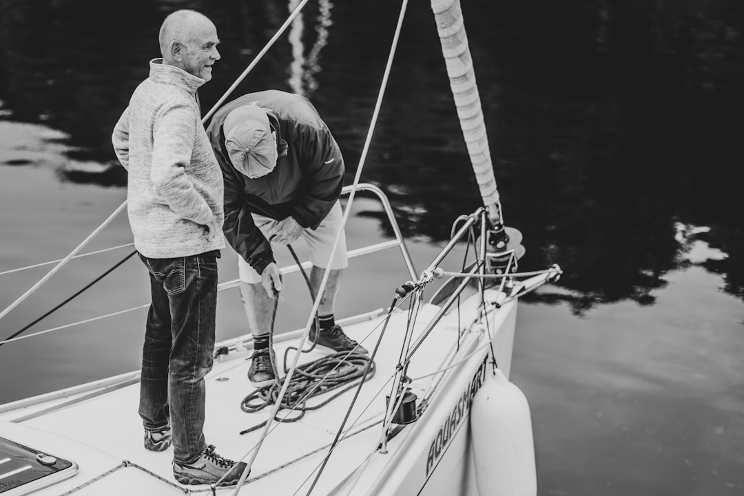 man and woman standing on white boat during daytime