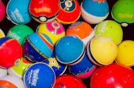 A lineup of colorful PU balls with custom logos displayed on a sleek black surface.