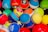 A collection of colorful Pokémon themed balls, each with distinct designs and logos. The balls are tightly packed together, showcasing a variety of vibrant colors and patterns.