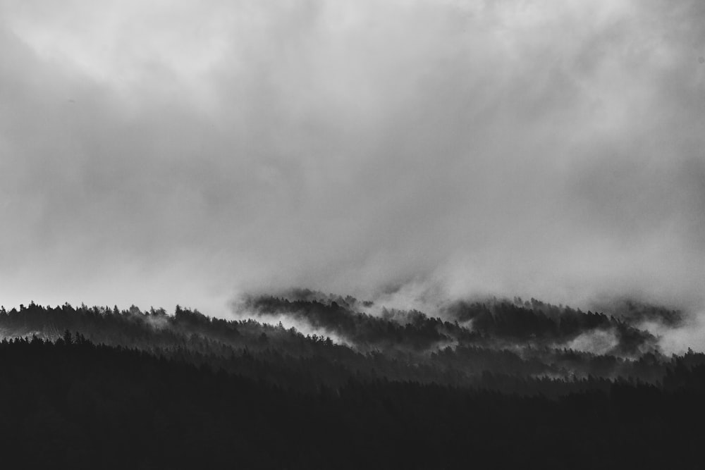 grayscale photo of clouds and mountain