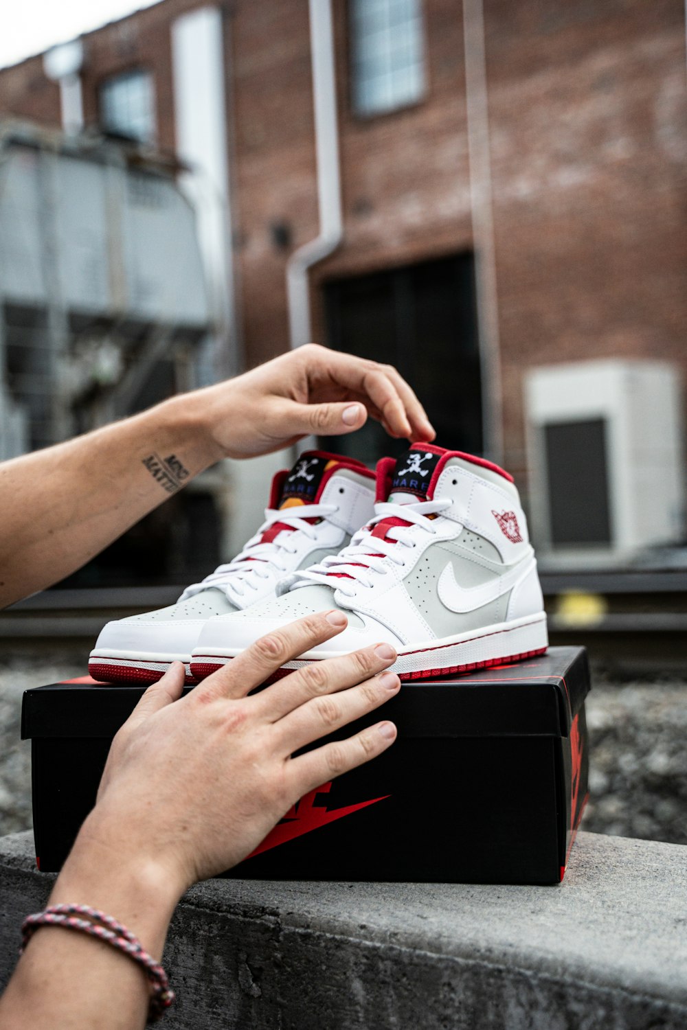 person holding white and red nike air max 90