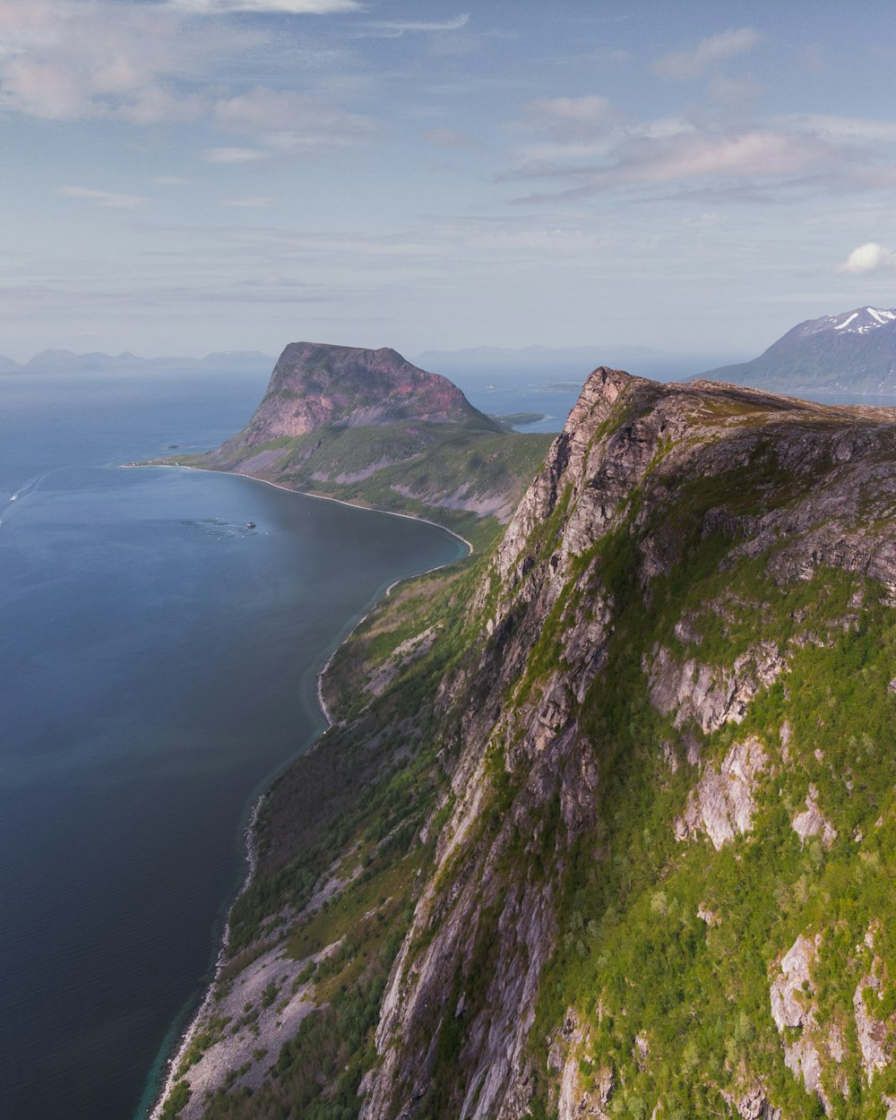 green and brown mountain beside body of water during daytime