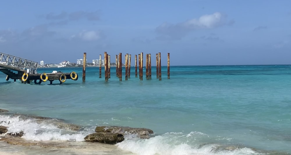 brown wooden posts on sea shore during daytime