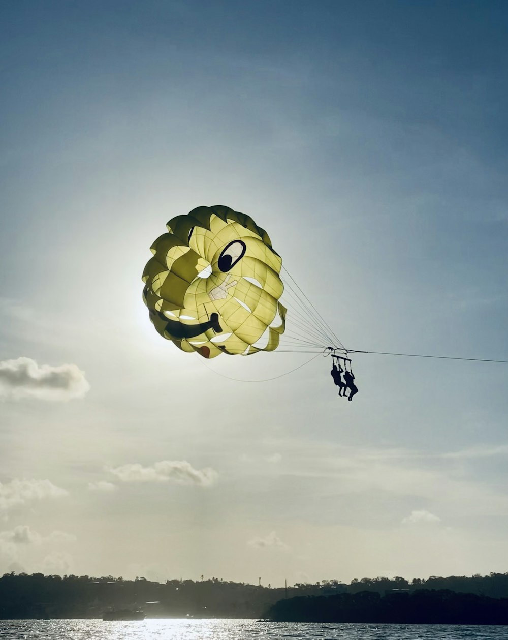 yellow and blue parachute under white clouds