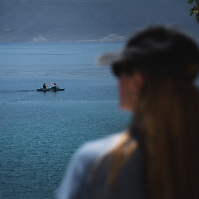 man and woman standing near body of water during daytime