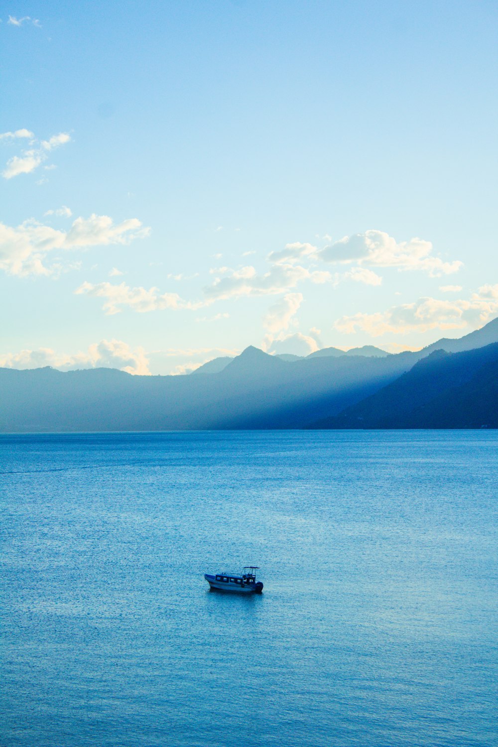 barco blanco en el mar azul bajo el cielo azul durante el día