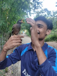 A caring bird owner interacting warmly with their exotic bird in a cozy home setting.