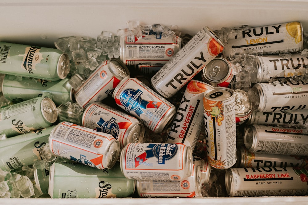 latas surtidas y latas sobre mesa blanca