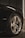 A close-up view of a car's chrome alloy wheel and tire, featuring a logo at the center. The wheel is shiny and well-maintained, with visible tire tread. A badge labeled 'HEMI' is visible on the car's dark paintwork, indicating a high-performance engine.