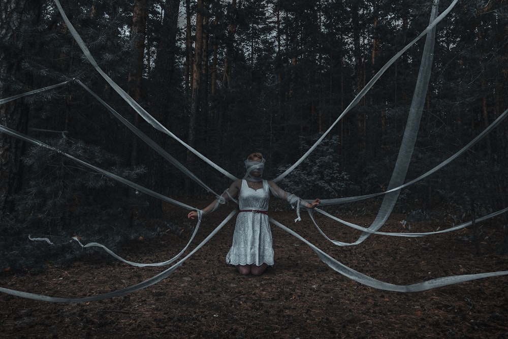 woman in white and red dress standing on forest during daytime