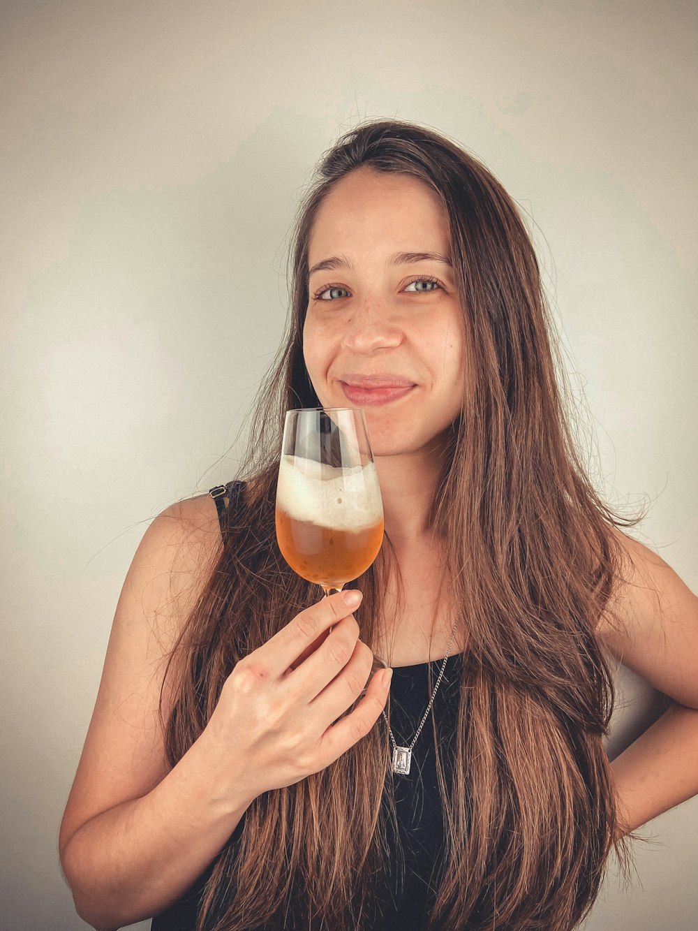 woman in black tank top holding clear drinking glass