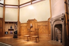 Elegant sitting area with a roaring fireplace and antique wooden furniture.