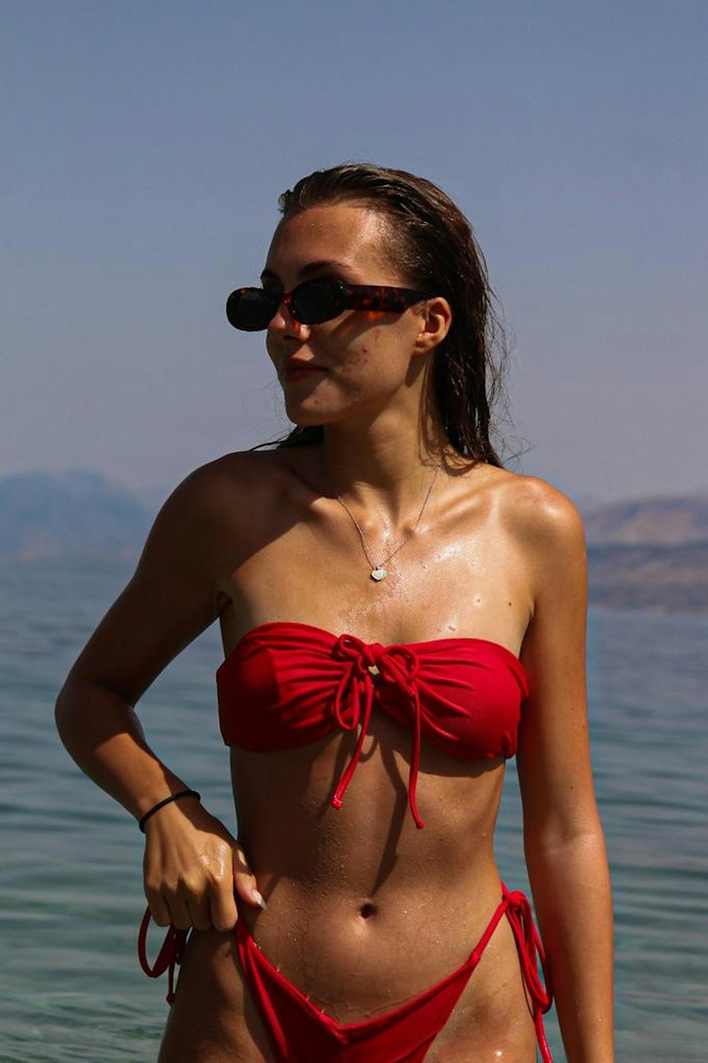 woman in red strapless bikini top wearing black sunglasses