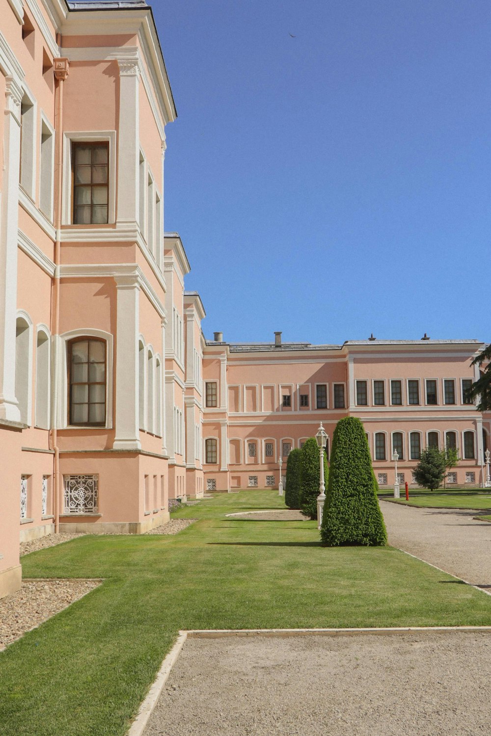 green grass lawn in front of white concrete building