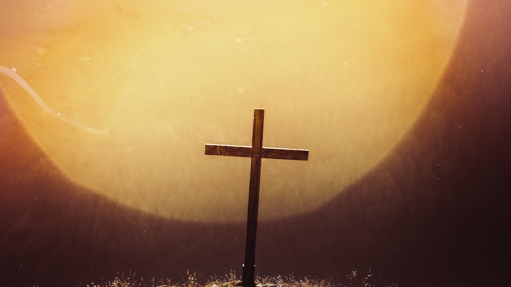 brown wooden cross on brown wall