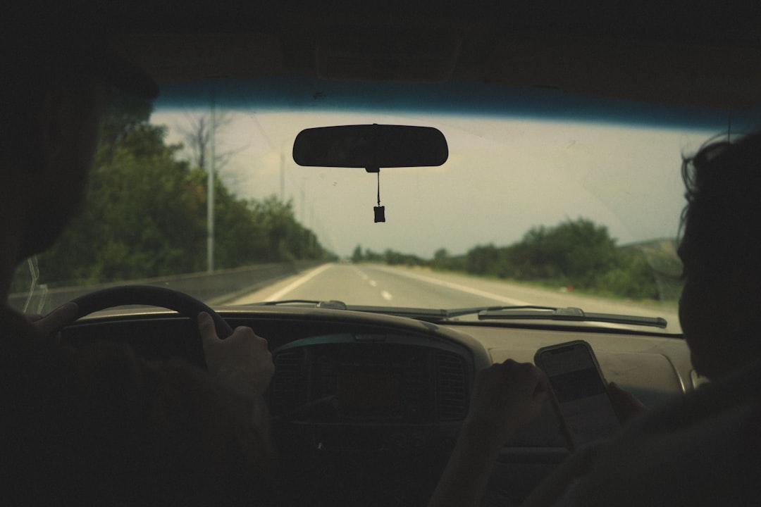 person driving car on road during daytime