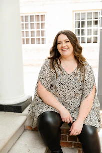 woman in black and white dress sitting on white concrete bench