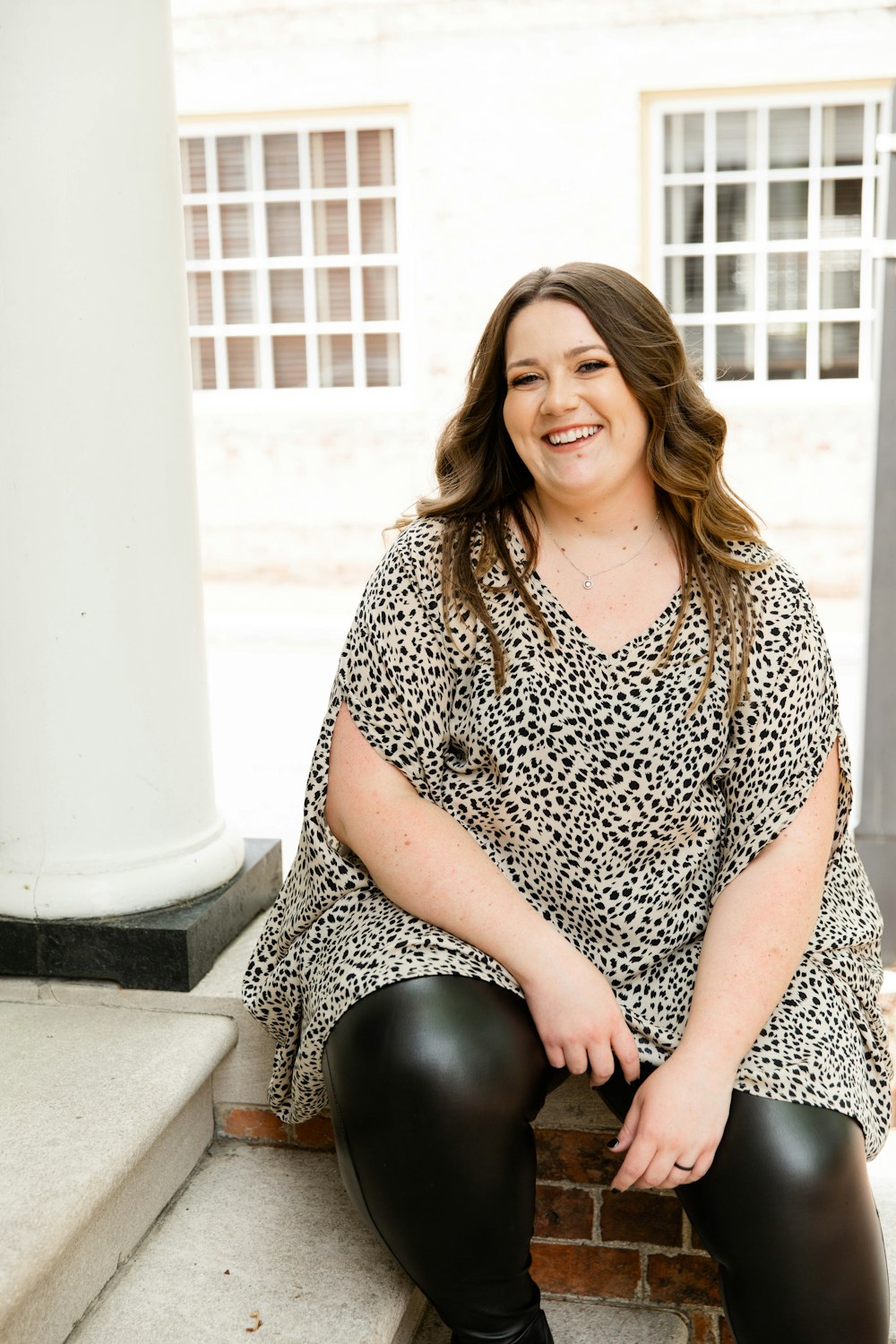 woman in black and white dress sitting on white concrete bench