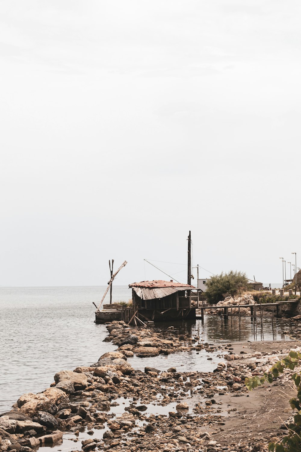 brown wooden house on brown rock formation near body of water during daytime