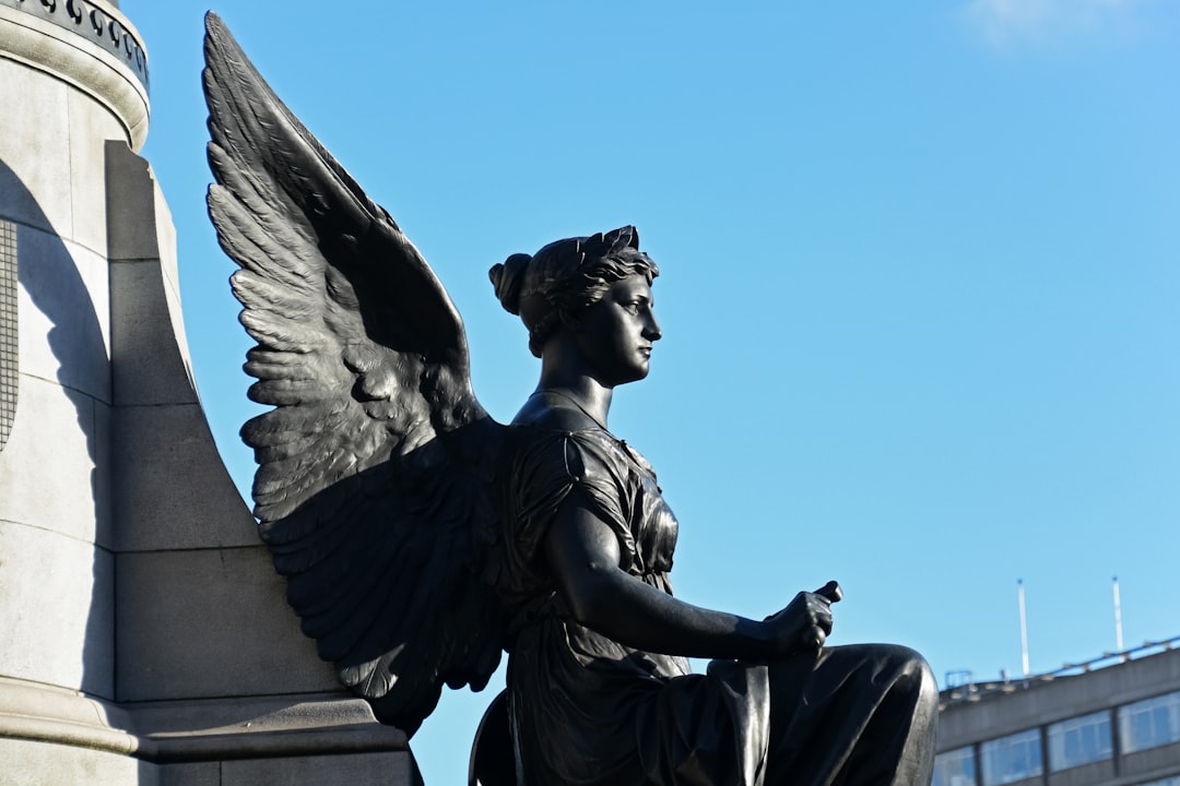 black statue of man holding book