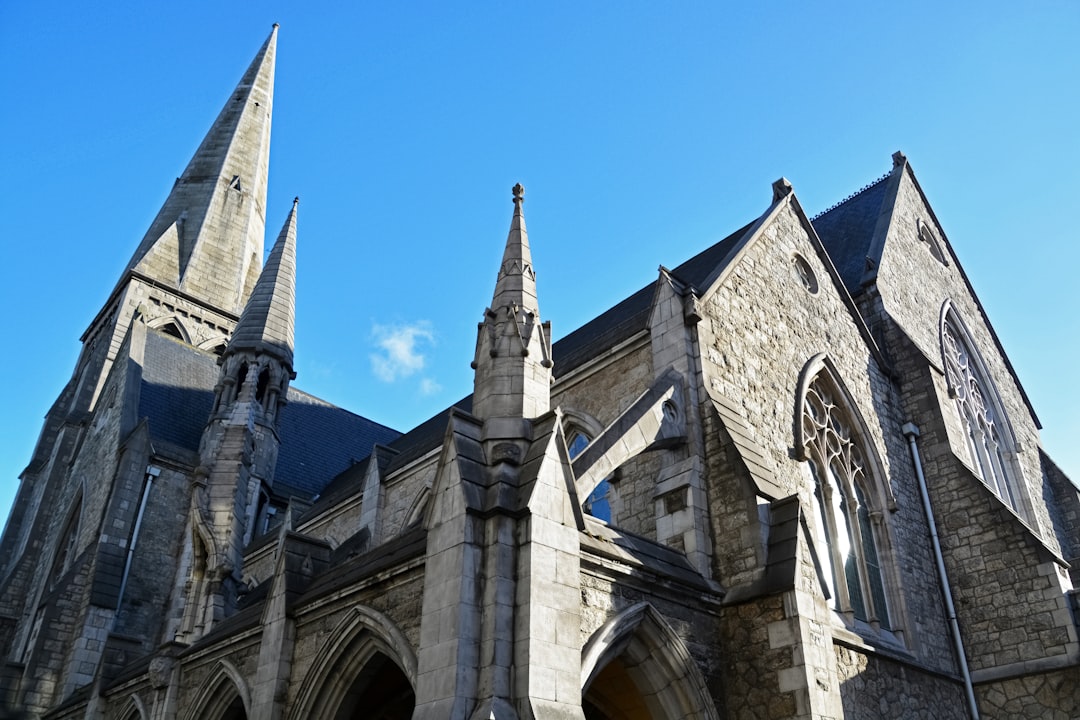 low angle photography of gray concrete building under blue sky during daytime