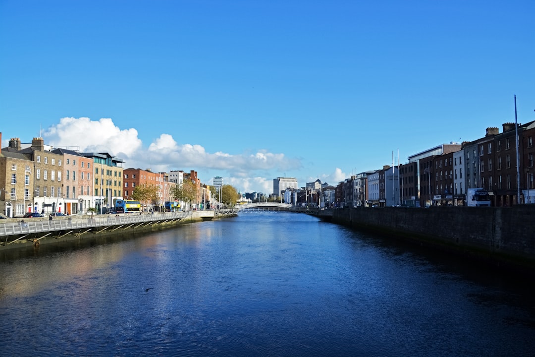 river between buildings under blue sky during daytime