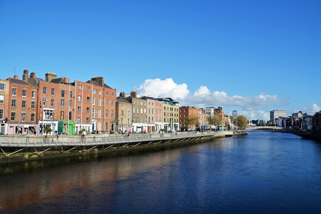 brown and white concrete buildings beside body of water under blue sky during daytime