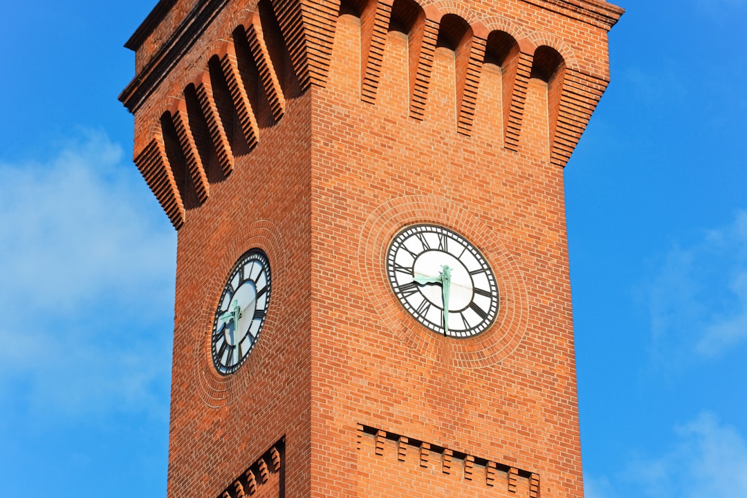 brown brick building with analog clock
