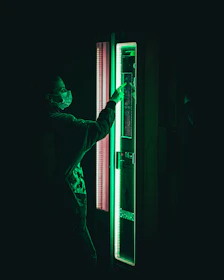Technician performing maintenance on a vending machine with glowing blue tools in a futuristic office setting.