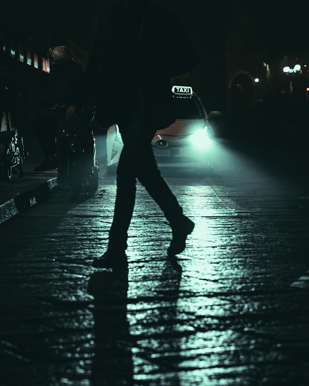 man in black jacket walking on street during night time