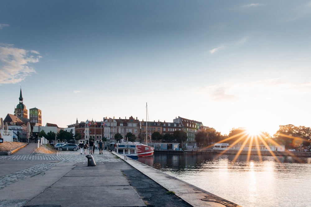 people walking on sidewalk near body of water during daytime