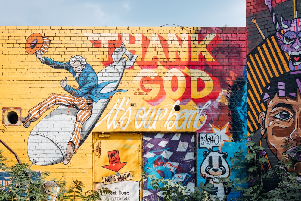 man in blue shirt and brown pants standing on wall with graffiti