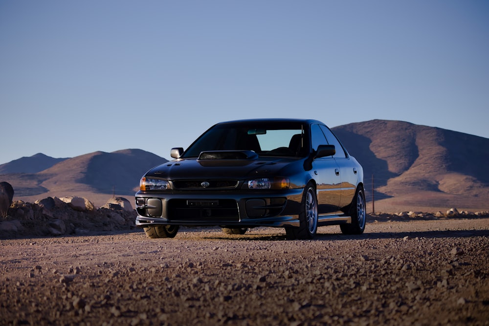 blue chevrolet camaro on brown sand during daytime