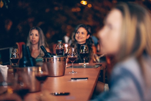 A group of professionals discussing strategies over a table with wine bottles and glasses.