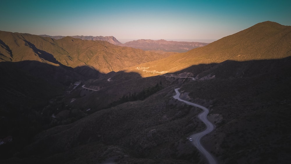 gray asphalt road between mountains during daytime