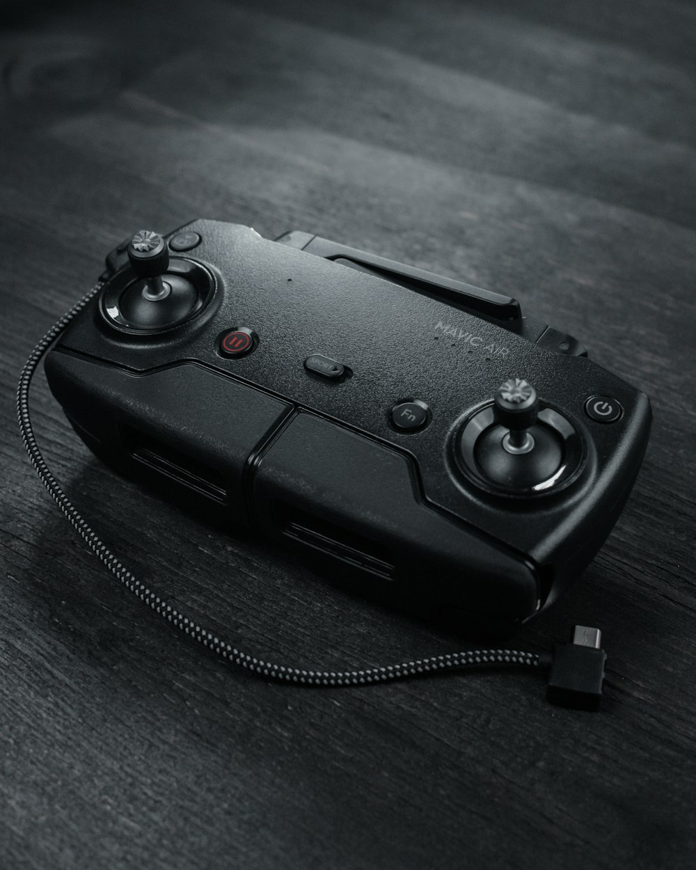 black corded game controller on black wooden table