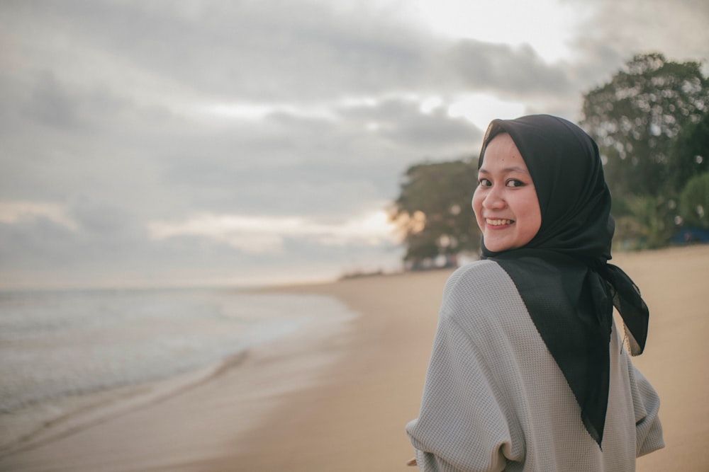 woman in white knit sweater and black hijab