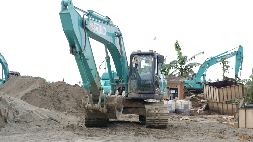 green and black excavator on brown sand during daytime