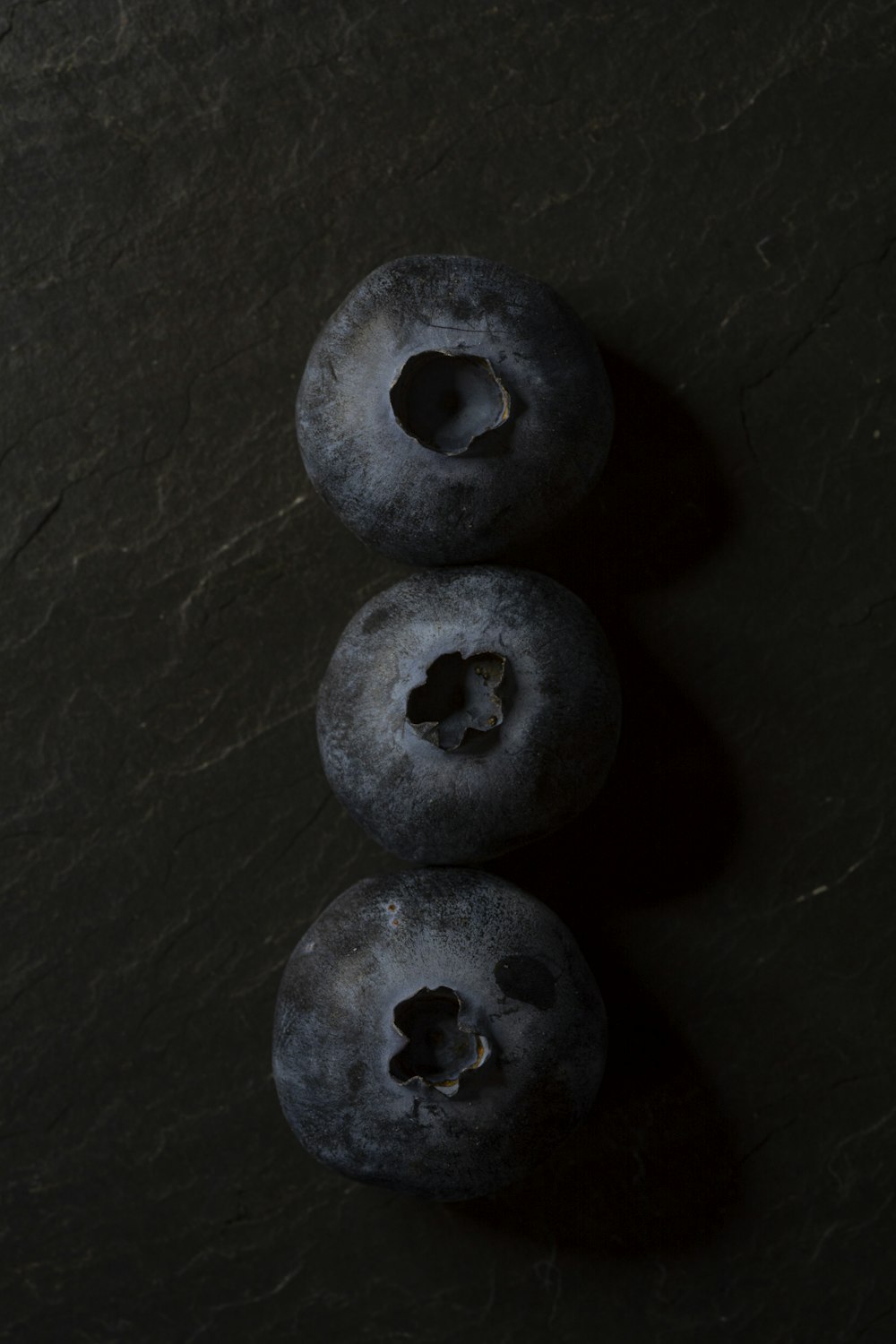3 round black stones on black surface